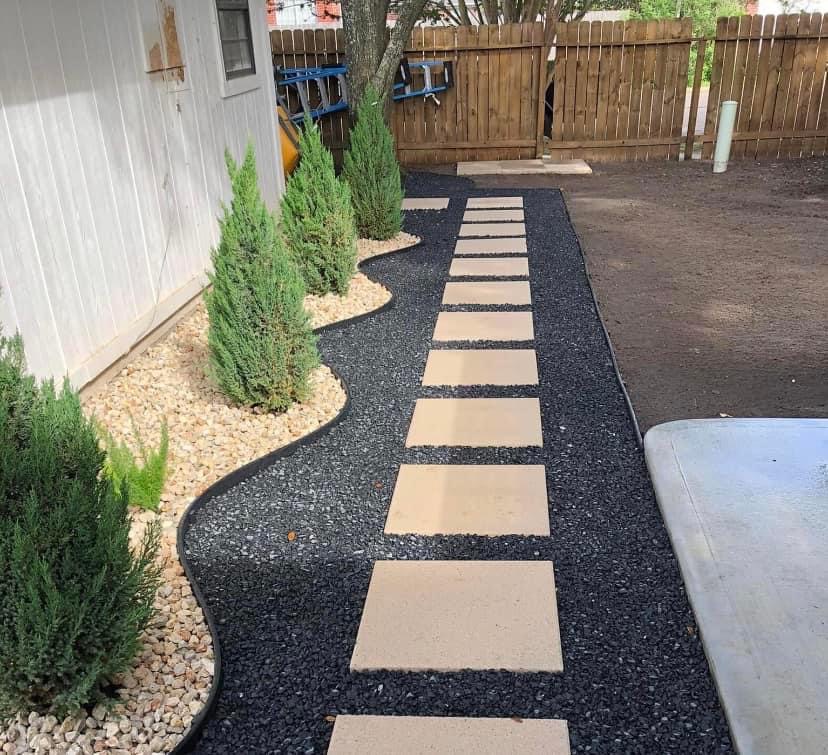 Custom paver walkway with black rock and shrub bed