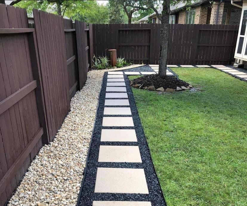 Stone-bordered paver path along privacy fence